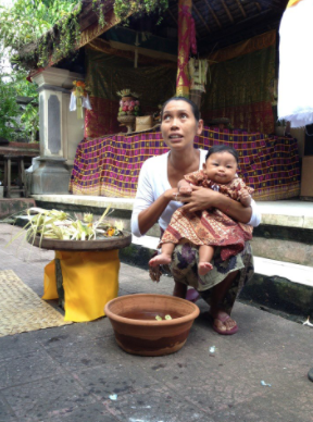 Balinese mother holding her baby to keep him off the ground.